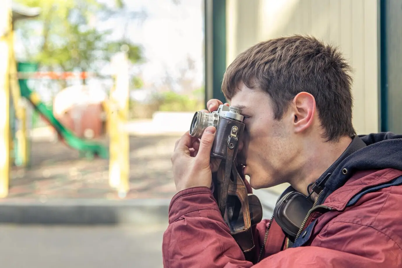 Ein junger Mann macht Fotos mit einer Vintage-Kamera; Filmfotografie.